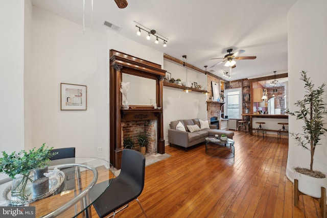 living room with a fireplace, hardwood / wood-style floors, and ceiling fan