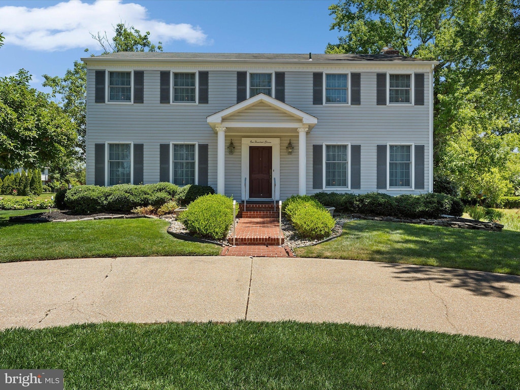 colonial home with a front lawn