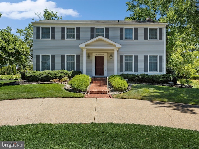 colonial home with a front lawn