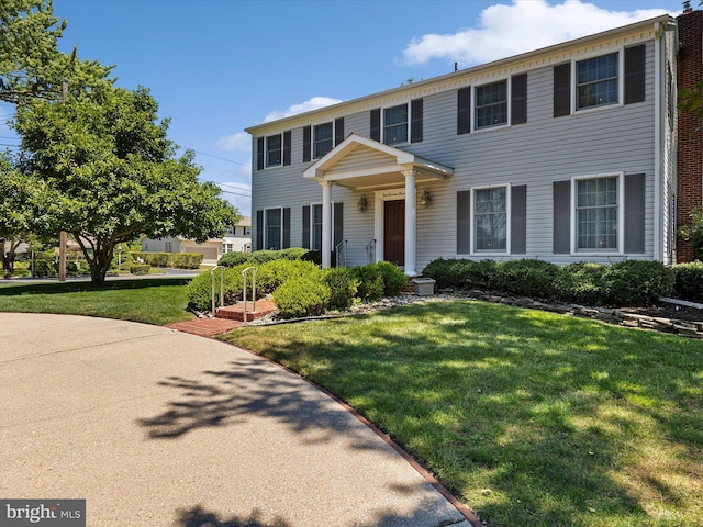 colonial-style house featuring a front yard