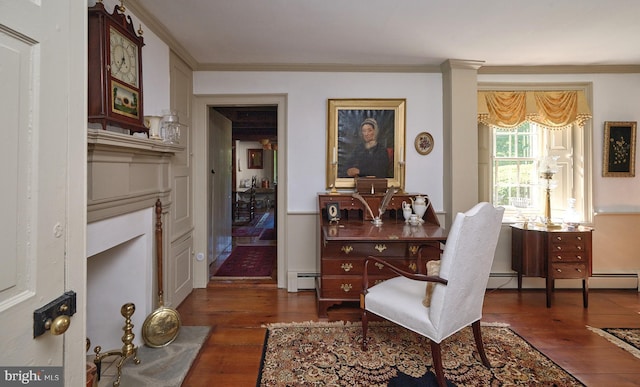 sitting room with dark hardwood / wood-style floors, ornamental molding, and a baseboard heating unit