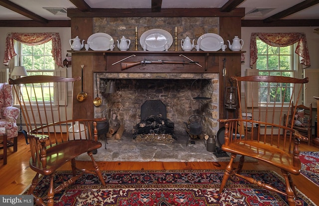 living room featuring a wealth of natural light, hardwood / wood-style floors, beamed ceiling, and a baseboard radiator