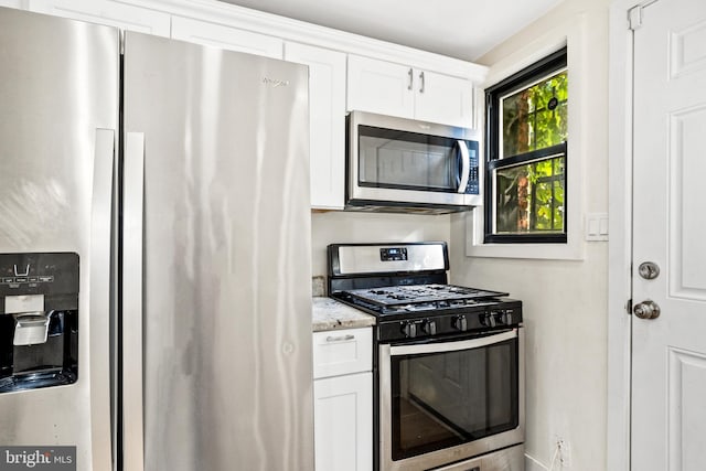 kitchen featuring light stone countertops, white cabinetry, and appliances with stainless steel finishes