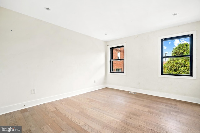 empty room featuring plenty of natural light and light wood-type flooring