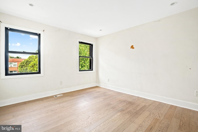 empty room with light wood-type flooring and a healthy amount of sunlight