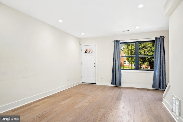 spare room with visible vents, baseboards, and light wood finished floors