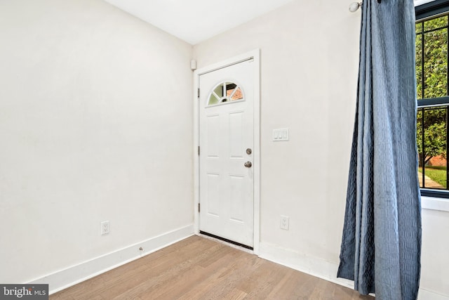 entryway featuring baseboards and wood finished floors