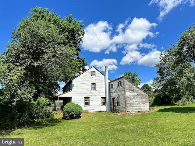 rear view of property featuring a yard