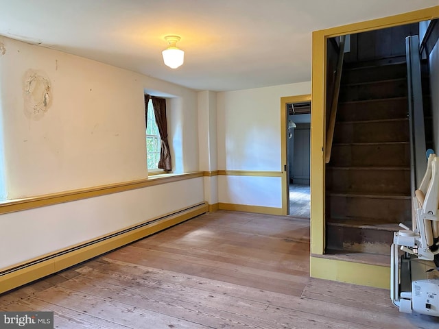 spare room featuring light wood-type flooring and a baseboard heating unit