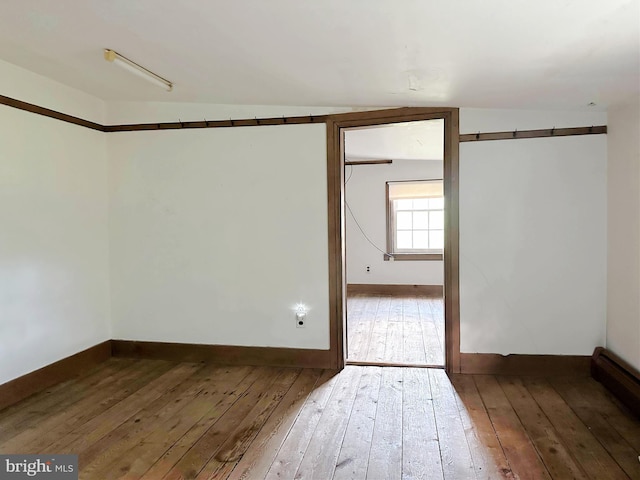 empty room with dark hardwood / wood-style floors and lofted ceiling