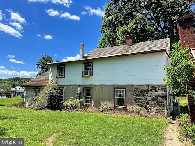 rear view of property featuring a lawn