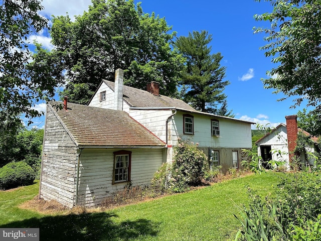 back of property featuring a lawn