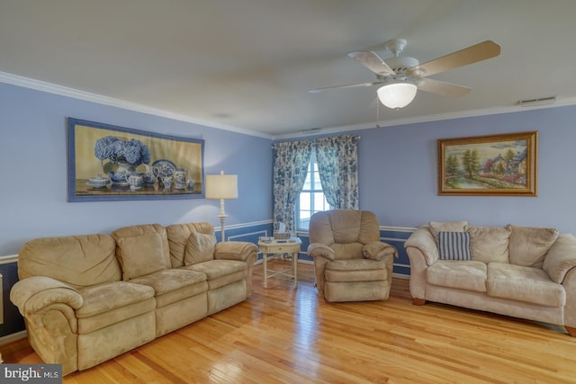 living room with hardwood / wood-style flooring, ceiling fan, and ornamental molding