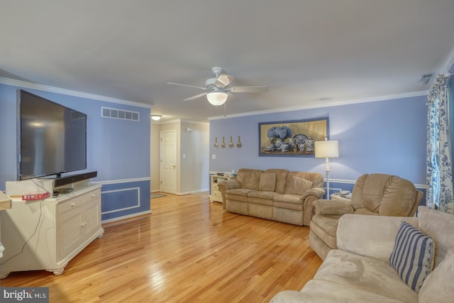 living room featuring light hardwood / wood-style floors, ceiling fan, and crown molding