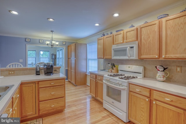 kitchen featuring light wood-type flooring, ornamental molding, white appliances, decorative light fixtures, and an inviting chandelier