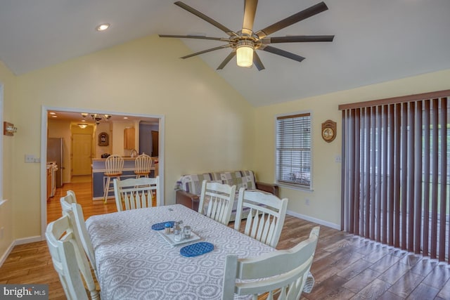 dining space with ceiling fan, high vaulted ceiling, and wood-type flooring