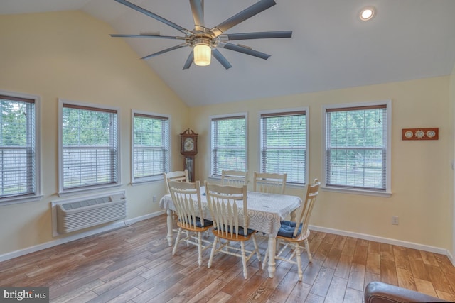 dining area with a wall mounted air conditioner, a wealth of natural light, and light hardwood / wood-style flooring