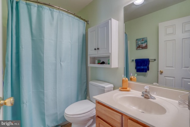 bathroom with vanity, curtained shower, and toilet