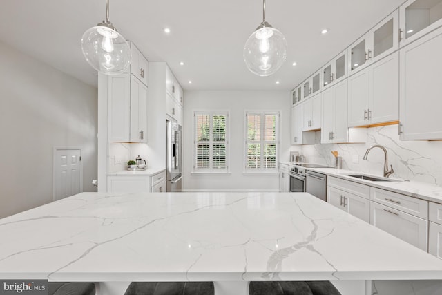 kitchen with backsplash, a kitchen bar, white cabinetry, and sink