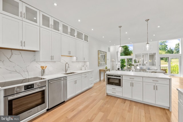 kitchen featuring backsplash, sink, white cabinets, and appliances with stainless steel finishes