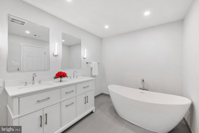 bathroom featuring tile patterned flooring, vanity, and a bathing tub