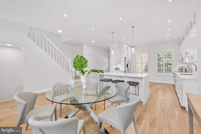 dining area with sink and light hardwood / wood-style floors