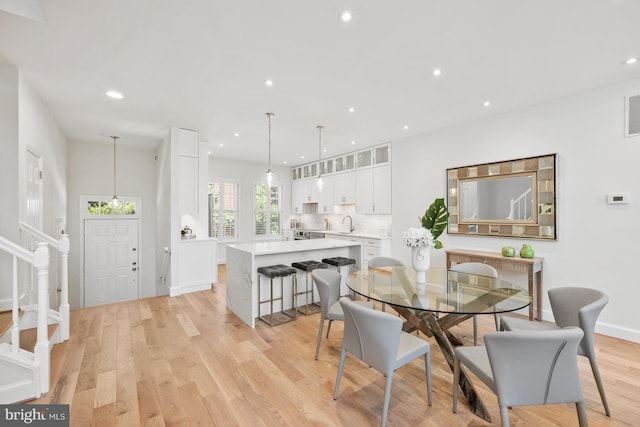 dining room featuring sink and light hardwood / wood-style flooring