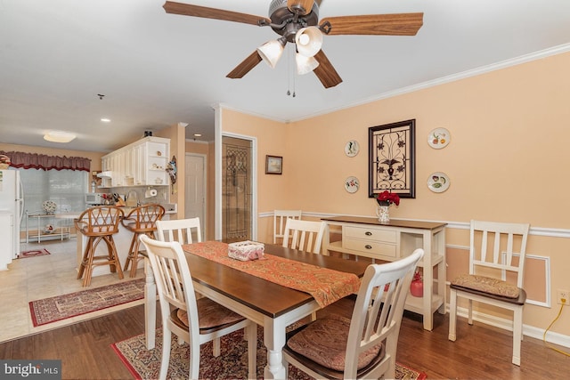 dining area with sink, hardwood / wood-style floors, and ornamental molding