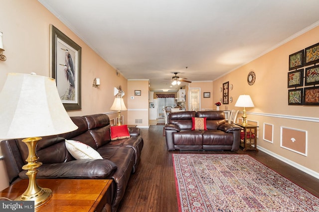 living room with crown molding, ceiling fan, and dark wood-type flooring