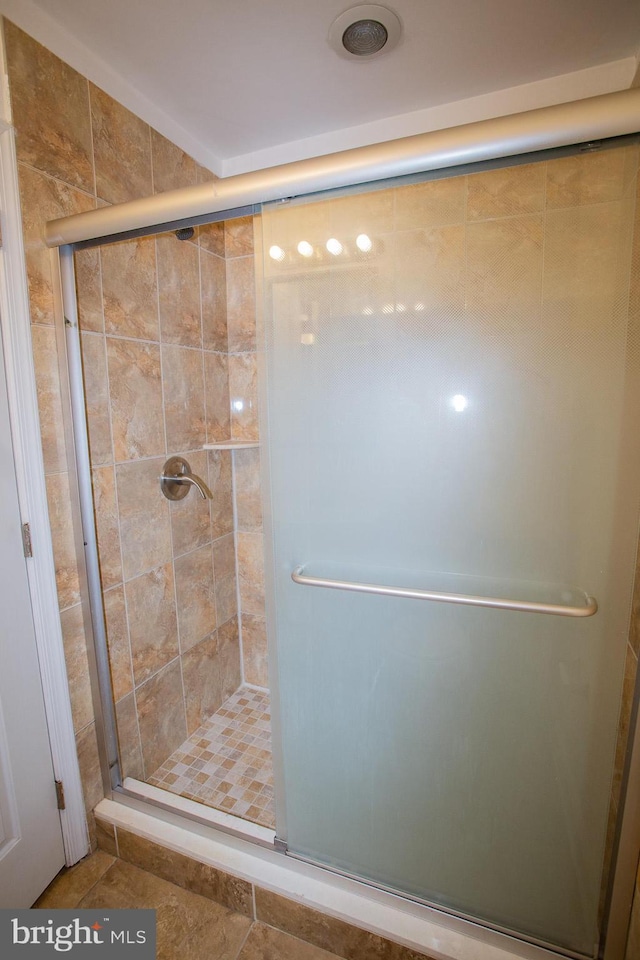 bathroom with tile patterned flooring and a shower with shower door