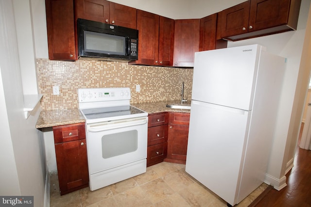 kitchen featuring tasteful backsplash, light stone counters, sink, and white appliances