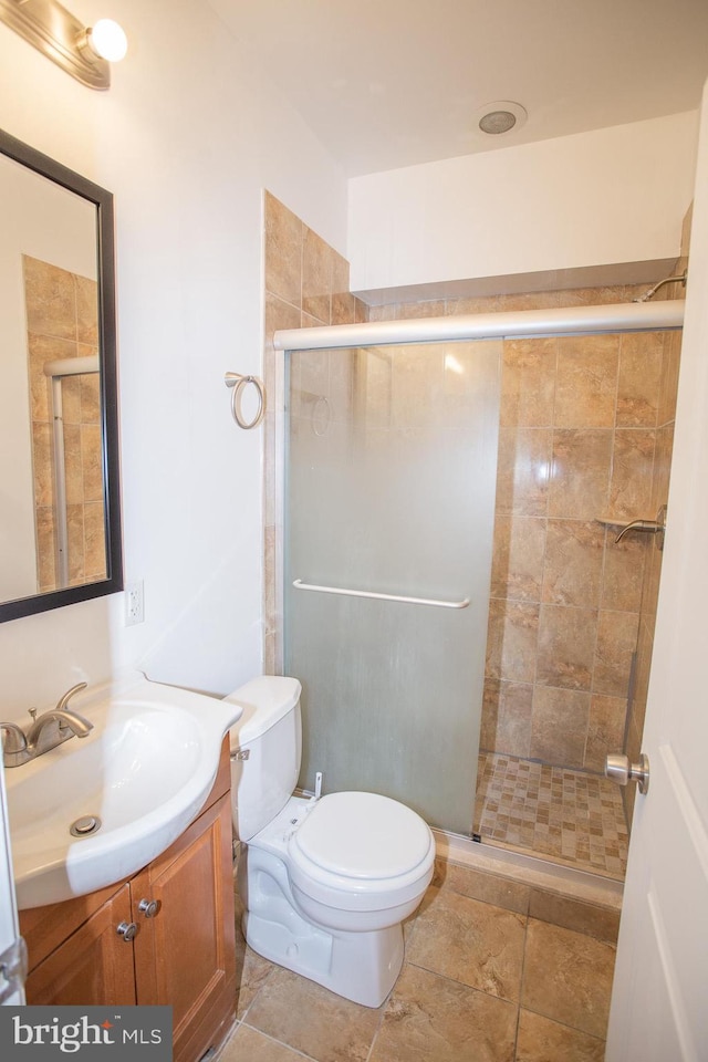 bathroom featuring vanity, toilet, and an enclosed shower