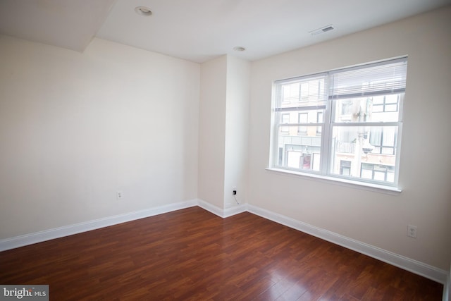 spare room featuring dark wood-type flooring