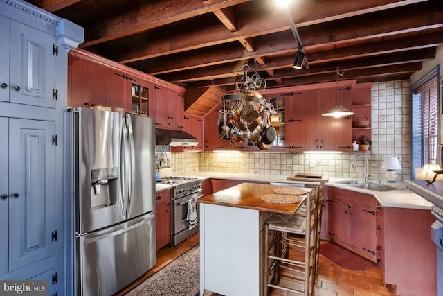 kitchen featuring sink, tasteful backsplash, beamed ceiling, pendant lighting, and appliances with stainless steel finishes