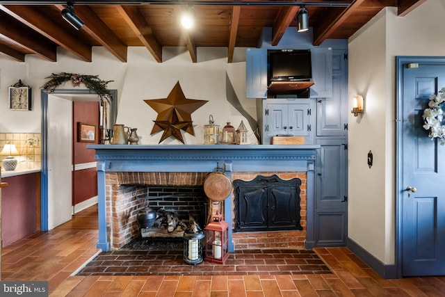 interior details with beamed ceiling, backsplash, a brick fireplace, and wooden ceiling