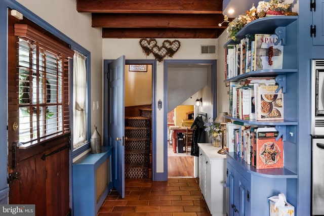 interior space featuring beamed ceiling and dark hardwood / wood-style floors