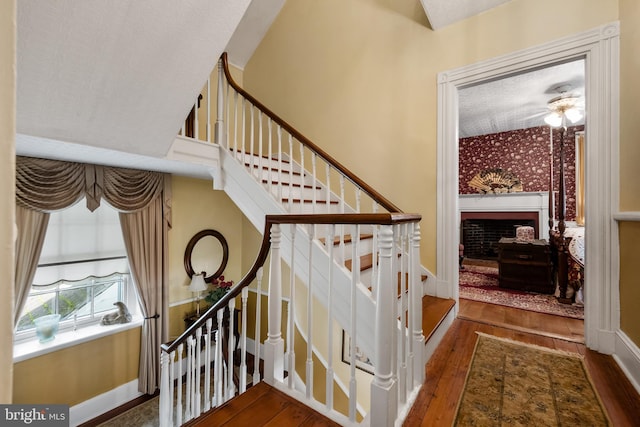 stairway with ceiling fan and hardwood / wood-style flooring