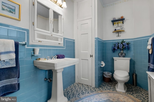 bathroom featuring tile patterned floors, tile walls, and toilet