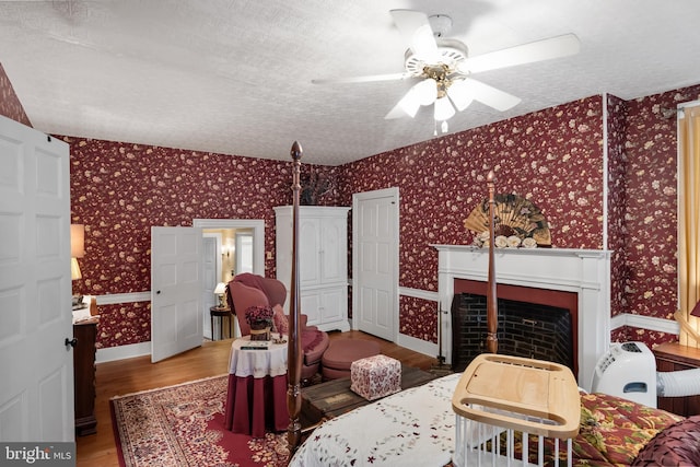 bedroom with hardwood / wood-style floors, a textured ceiling, and ceiling fan