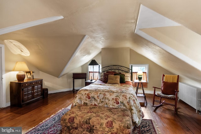 bedroom featuring dark hardwood / wood-style flooring, radiator heating unit, and vaulted ceiling