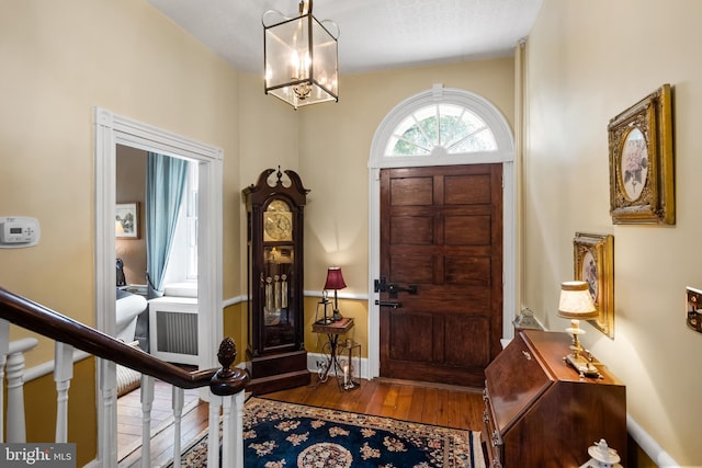 foyer featuring wood-type flooring and an inviting chandelier