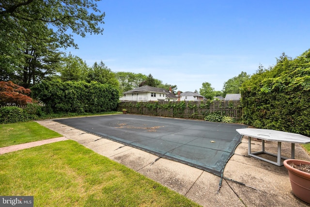 view of swimming pool featuring a patio area and a yard