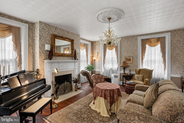 living area with dark hardwood / wood-style flooring, a textured ceiling, and a chandelier