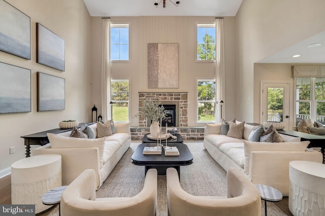 living room featuring a fireplace, a high ceiling, and a healthy amount of sunlight