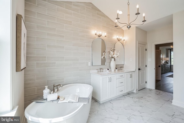 bathroom featuring vanity, lofted ceiling, a tub to relax in, tile walls, and a chandelier