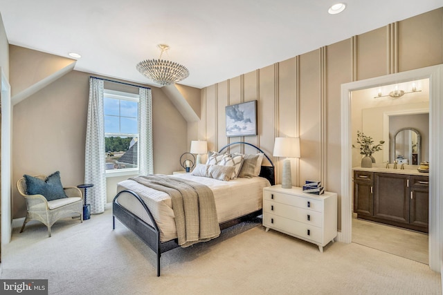 bedroom featuring ensuite bathroom, light colored carpet, and vaulted ceiling