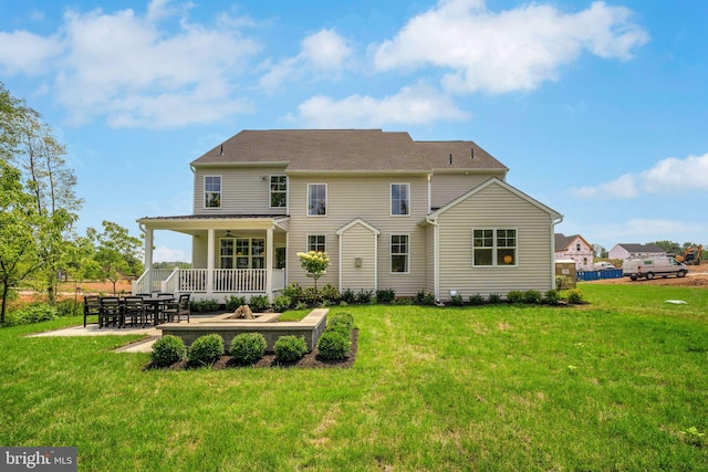 back of property with covered porch, a yard, and a patio