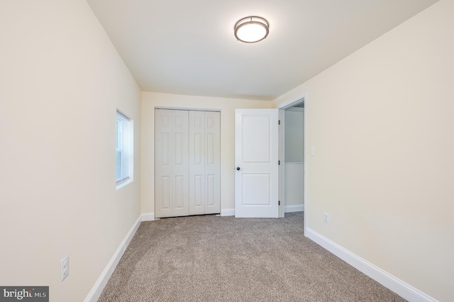 unfurnished bedroom featuring a closet and light colored carpet