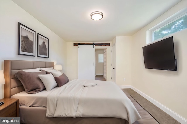 bedroom featuring carpet flooring and a barn door