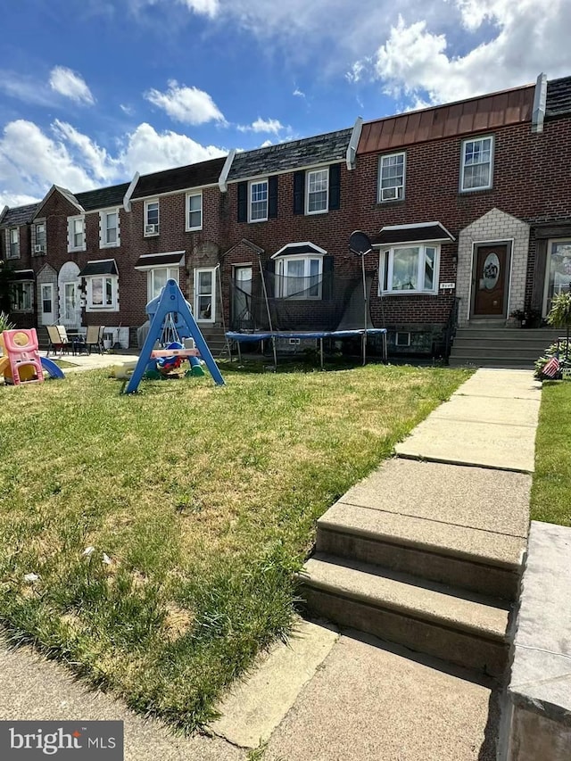 view of community with a trampoline and a lawn